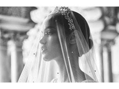 Woman wearing a wedding veil with beaded detailing and a bridal crown