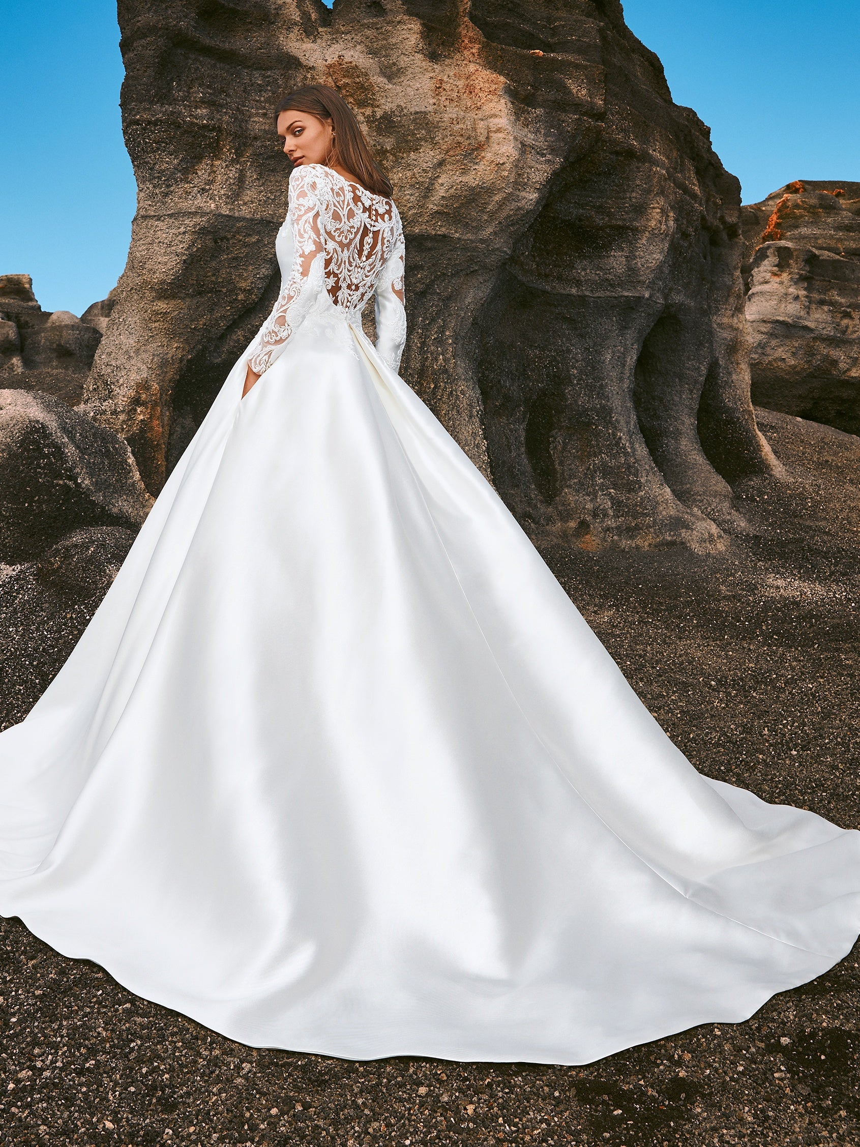 Cremefarbenes, schulterfreie Brautkleid aus weichem Tüll mit zarten Spitzenapplikationen in Form von Blütenblättern, die über die Corsage mit herzförmigem Dekolleté und den eleganten Rock im Prinzessin-Stil gestreut sind. 