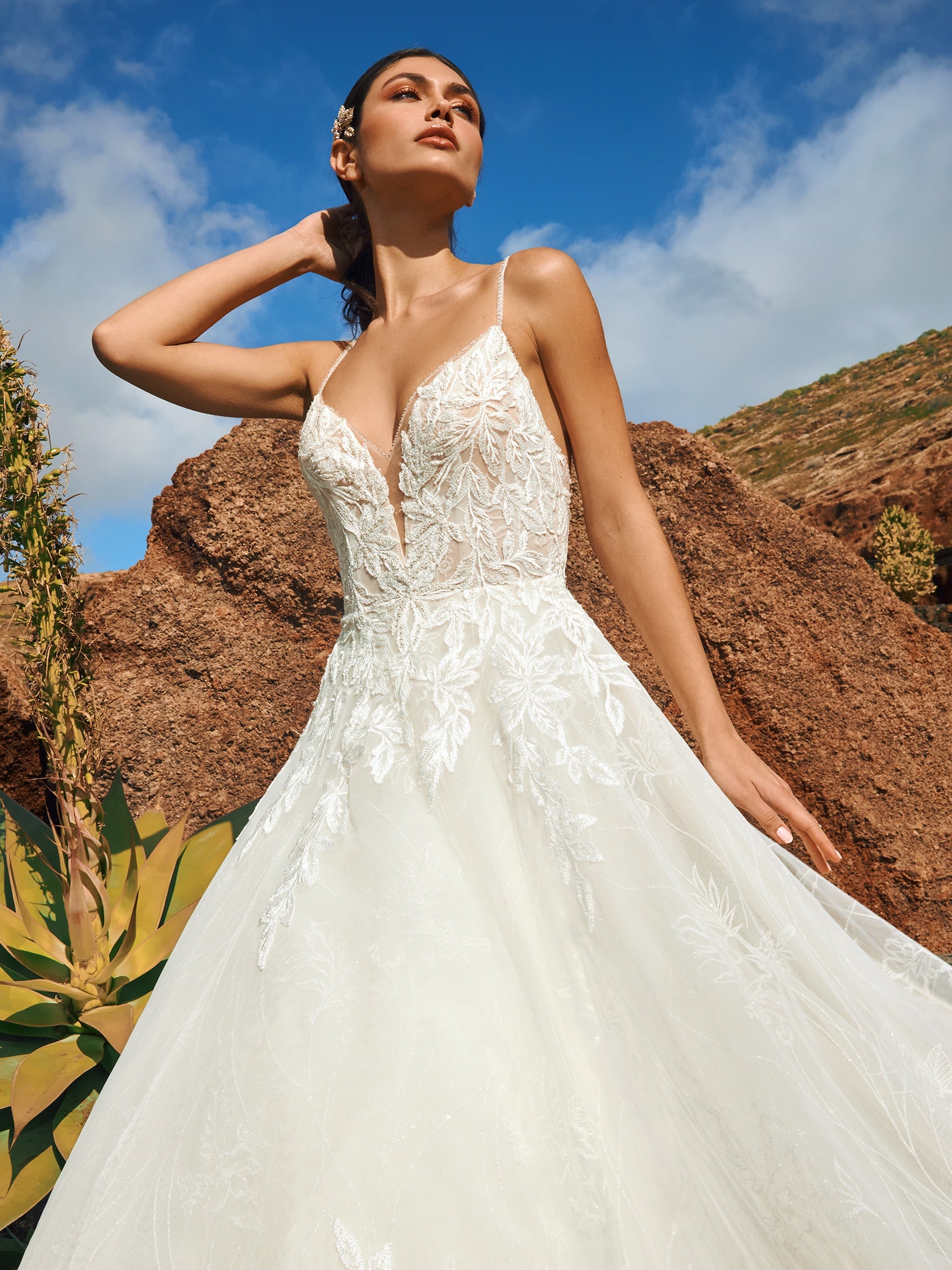 Eine zeitlose Couture-Silhouette aus elegant schimmerndem Mikado mit ausladendem Rock und herzförmigem Ausschnitt, der das Dekolleté gekonnt in Szene setzt. Der tiefe Rückenausschnitt und die Flügelärmel im trendigen Design betonen die Feminität der Braut.