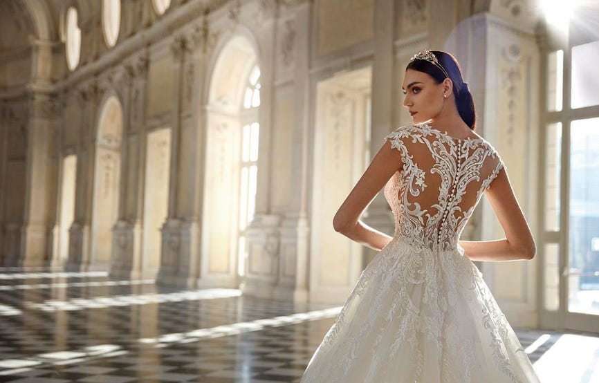 Noiva posando de costas, mostrando os detalhes bordados do vestido de princesa rodado combinado com uma tiara