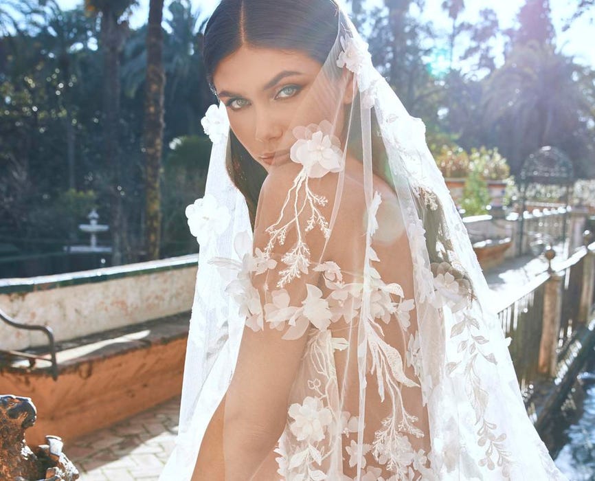 Woman wearing a floral wedding veil to match with her floral bridal dress