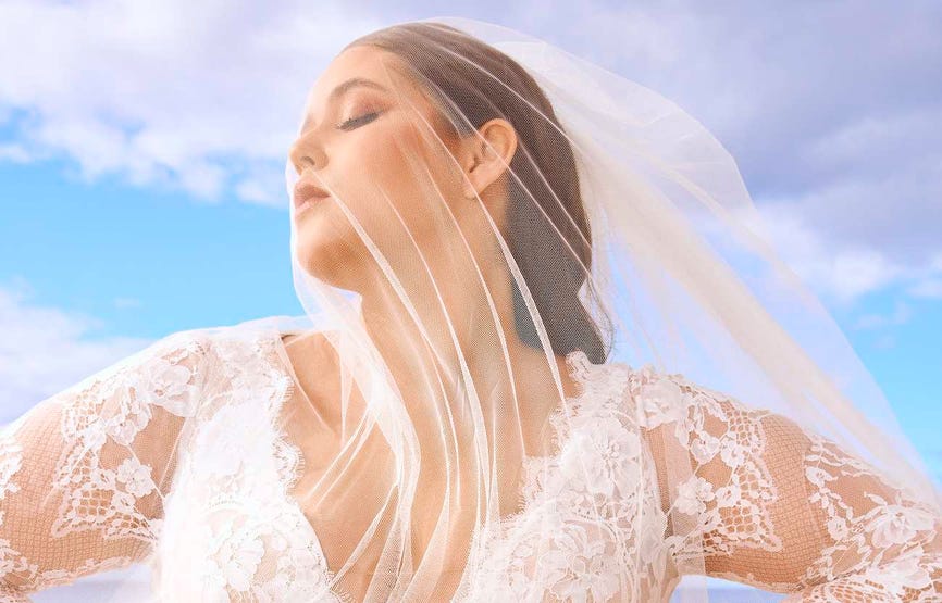 Woman wearing a V-neck lace long-sleeved wedding dress with a simple white bridal veil