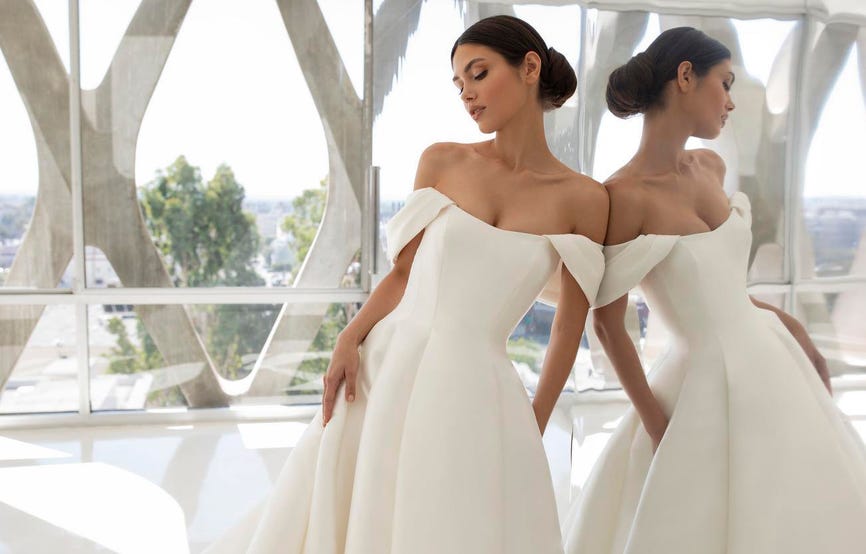 Mujer frente a un espejo con vestido de novia y un recogido tendencia