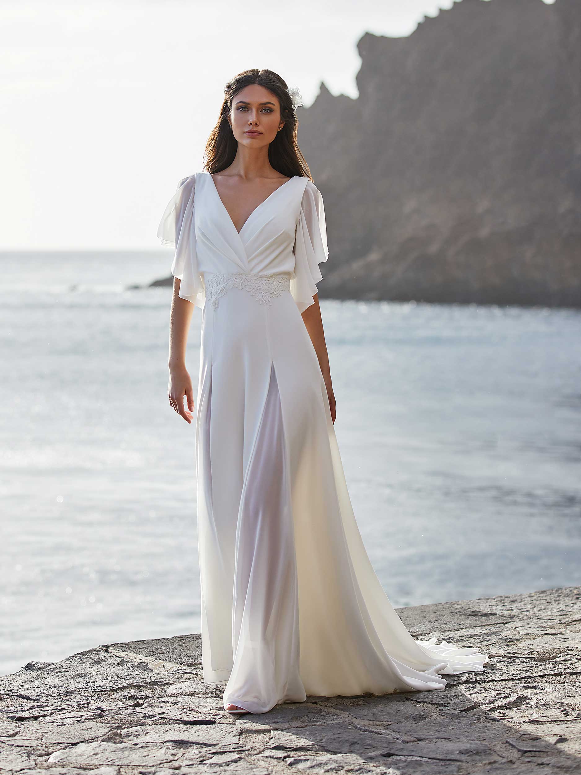 Mujer en la playa mostrando como lucir un vestido de novia en la playa.