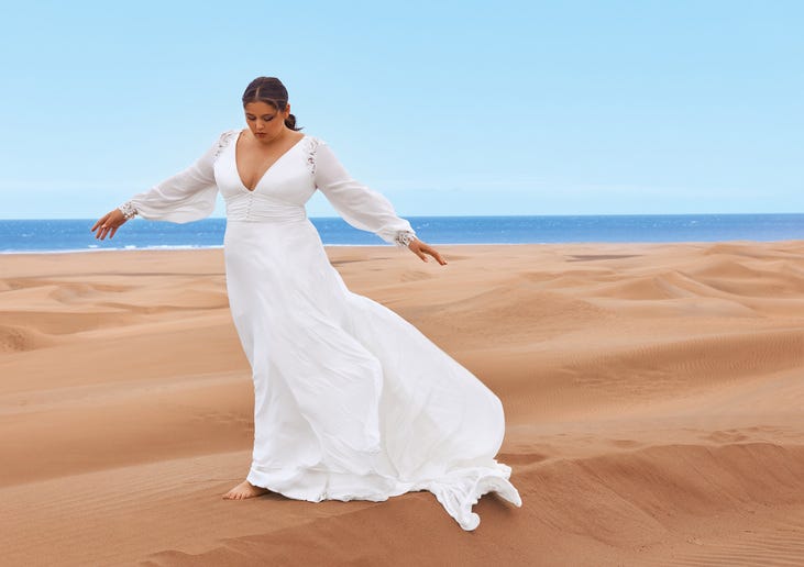 Woman wearing a v-neck long-sleeved wedding dress in an a-line cut.