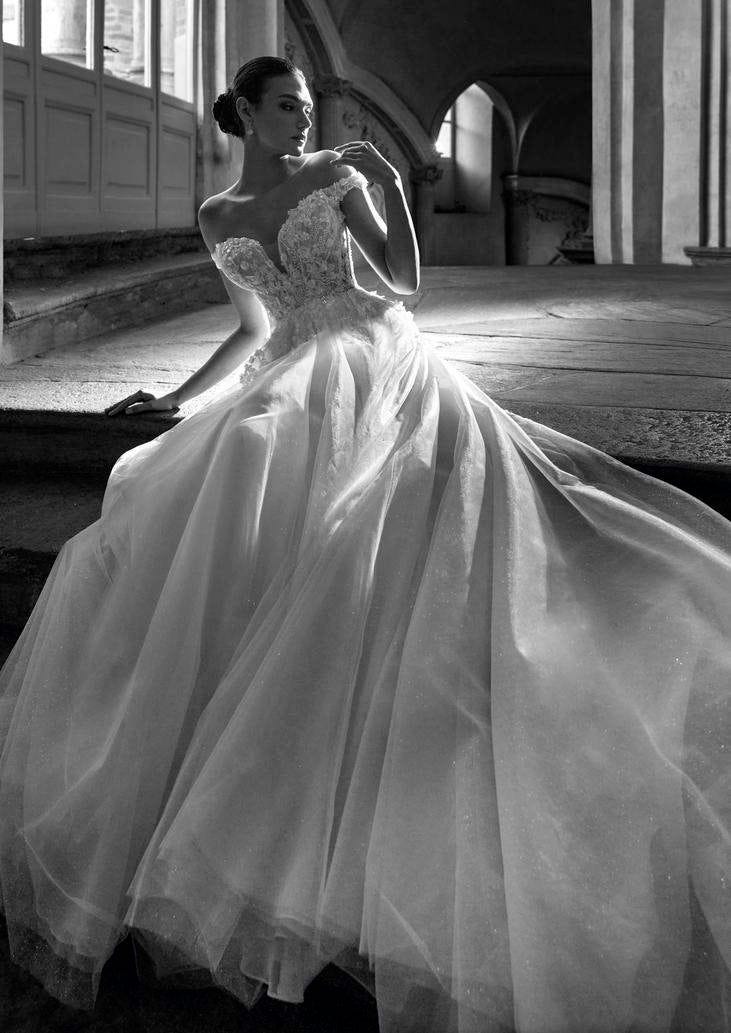 Mujer en blanco y negro sentada es una escalera de piedra con un vestido de novia