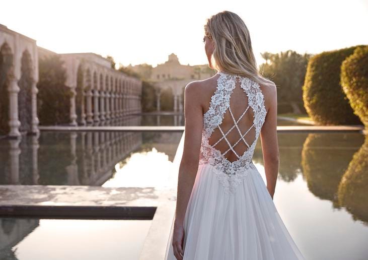 Kobieta w sukni ślubnej stojąca tyłem patrząca się na piękny widok ogrodów i basenów historycznego miejsca