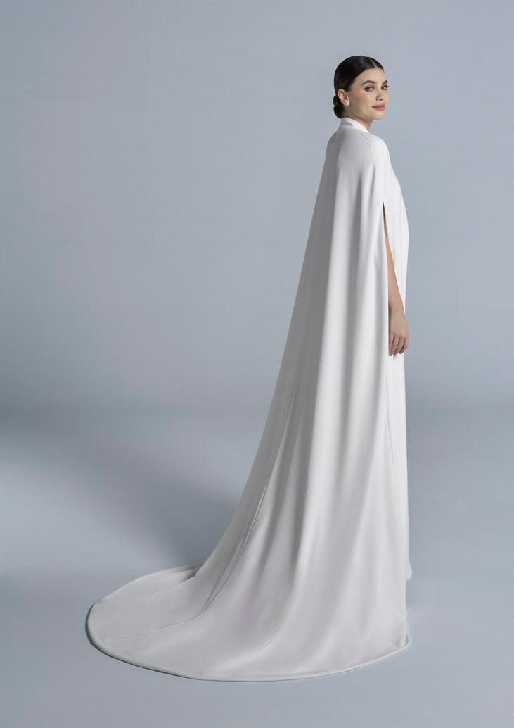 Kobieta stojąca tyłem prezentująca w elegancki prosty płaszcz ślubny 