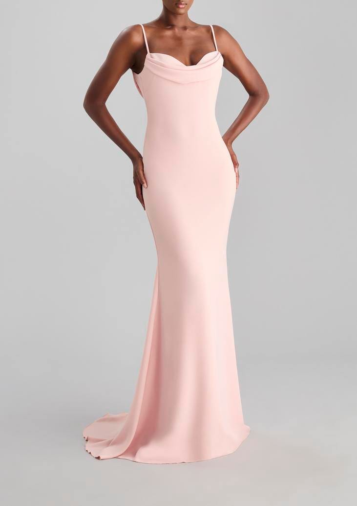 Modella che indossa un modello di abito da cerimonia per testimone a sirena rosa con spalline fini.