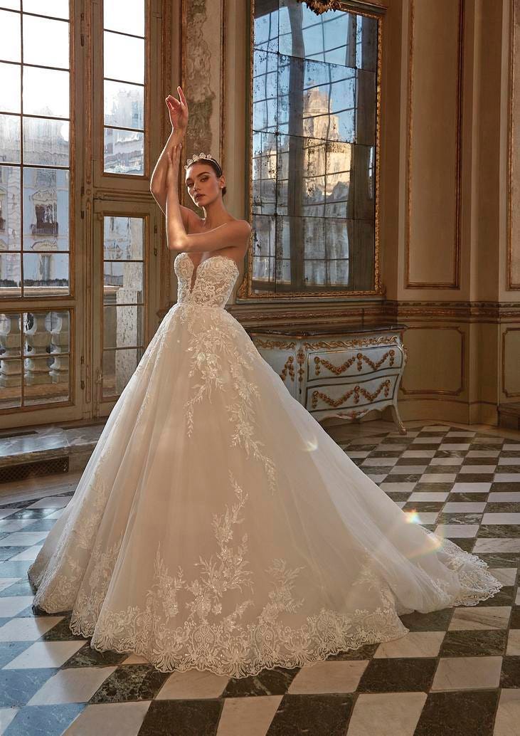 Noiva posando com um vestido princesa adornado com bordados conjugado com uma tiara brilhante
