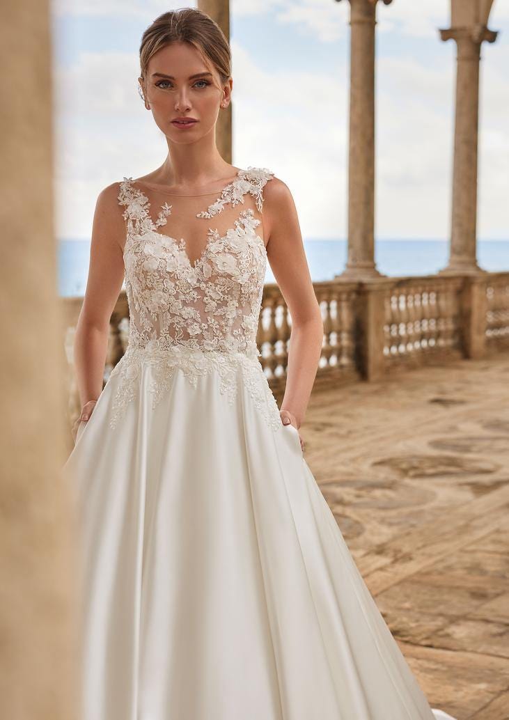 Une robe de mariée civile luxueuse en dentelle et satin, avec un haut transparent et une silhouette élégante.