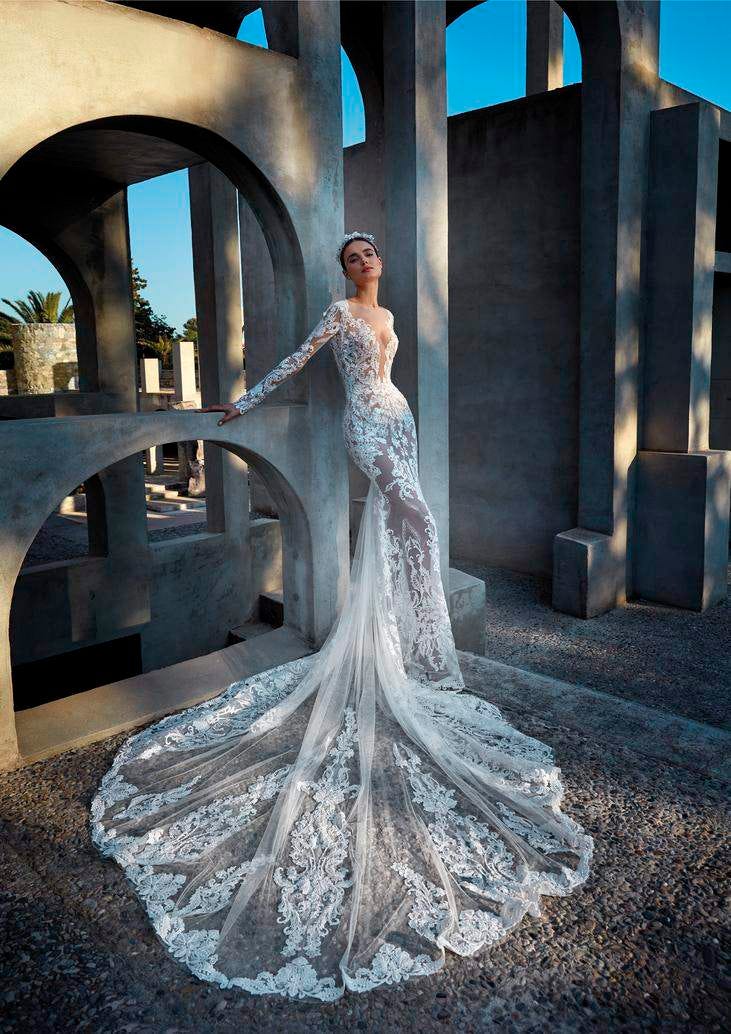 Une mariée élégante dans une robe de mariée en dentelle transparente à manches longues, décolleté en V et traîne