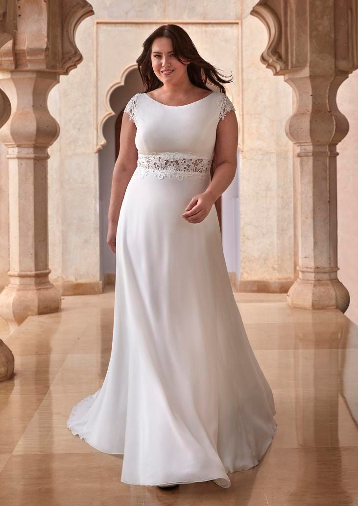 Woman in a plus-size wedding dress with an A-line silhouette in satin.