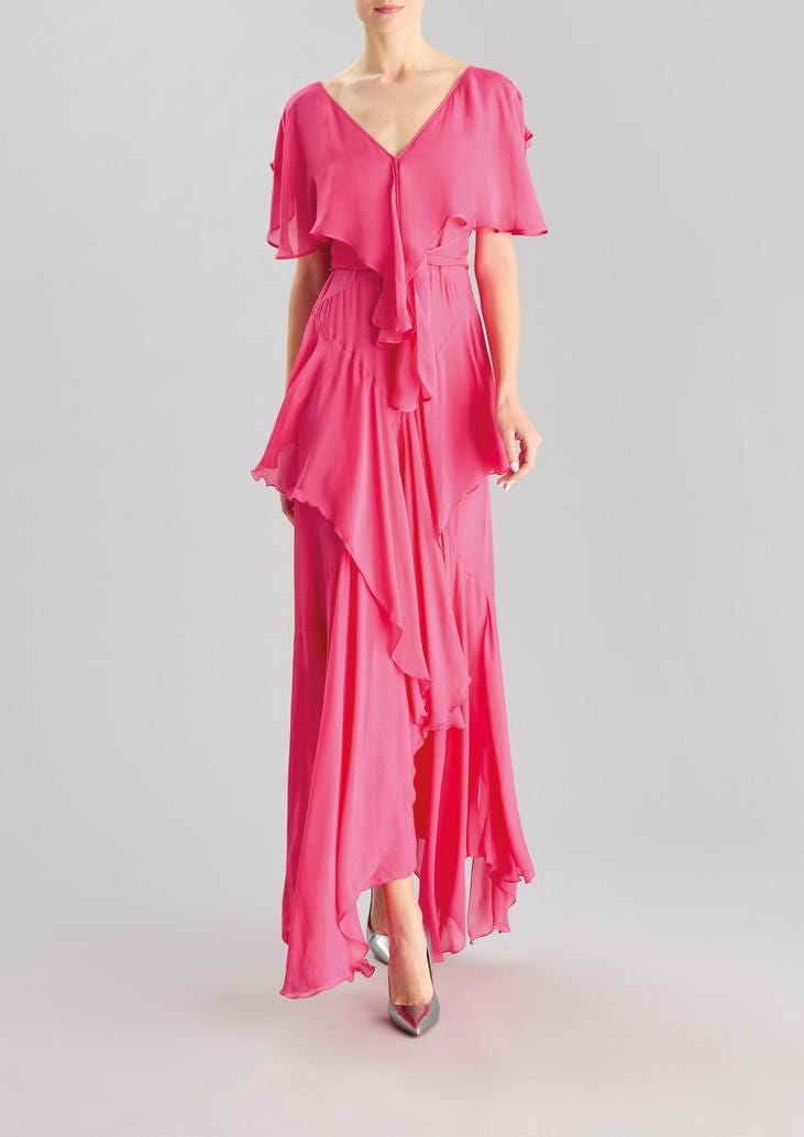 Convidada usando um vestido longo rosa, confecionado com um tecido fluído e leve com babados