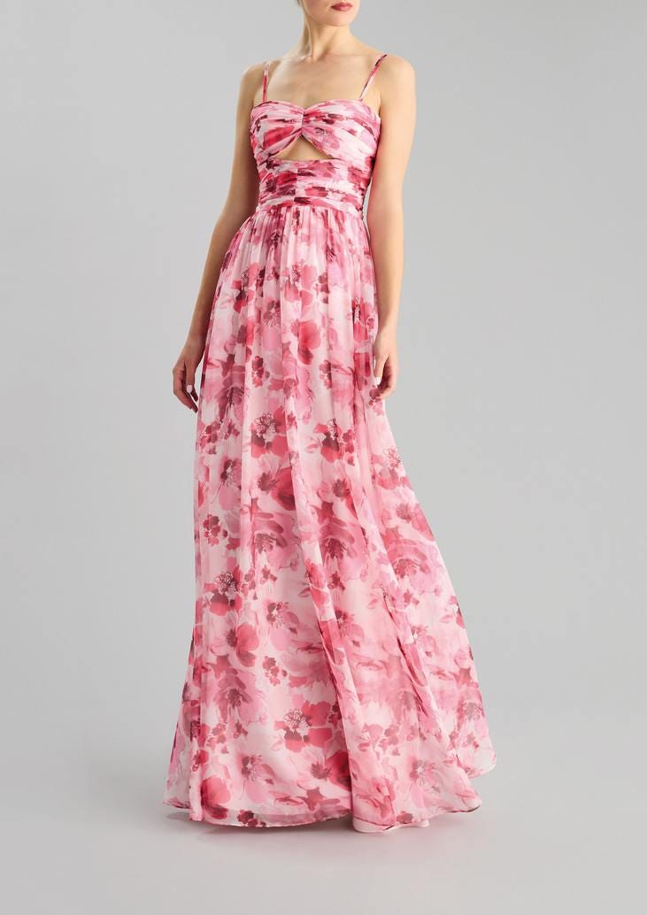 Kobieta w długiej sukience na poprawiny w kolorze różowym z motywem kwiatowym na cienkich ramiączkach