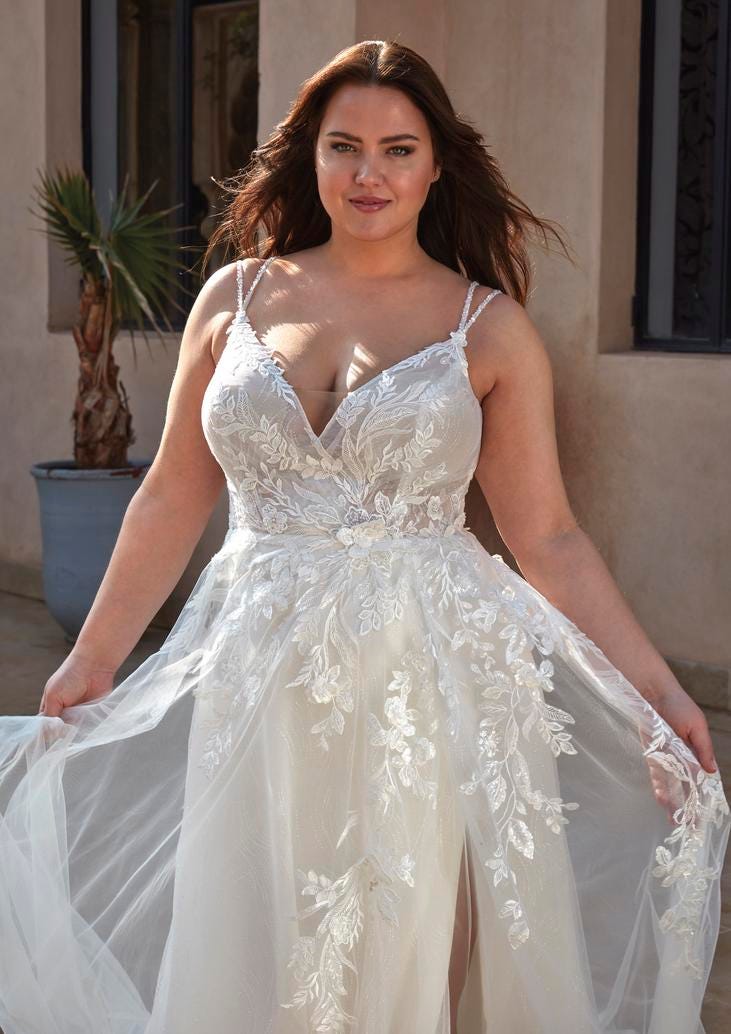 Brunette woman in a spaghetti strap A-line wedding dress with lace detailing lining the bodice