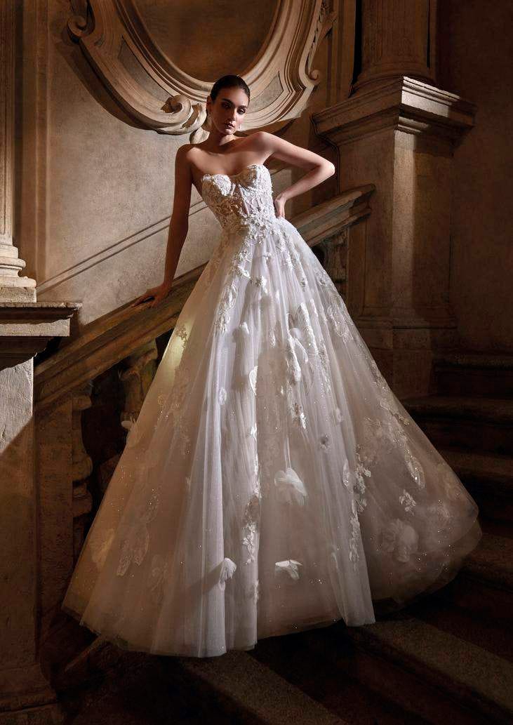 Modella su scalinata che indossa un abito da sposa stile principesco decorato senza spalline