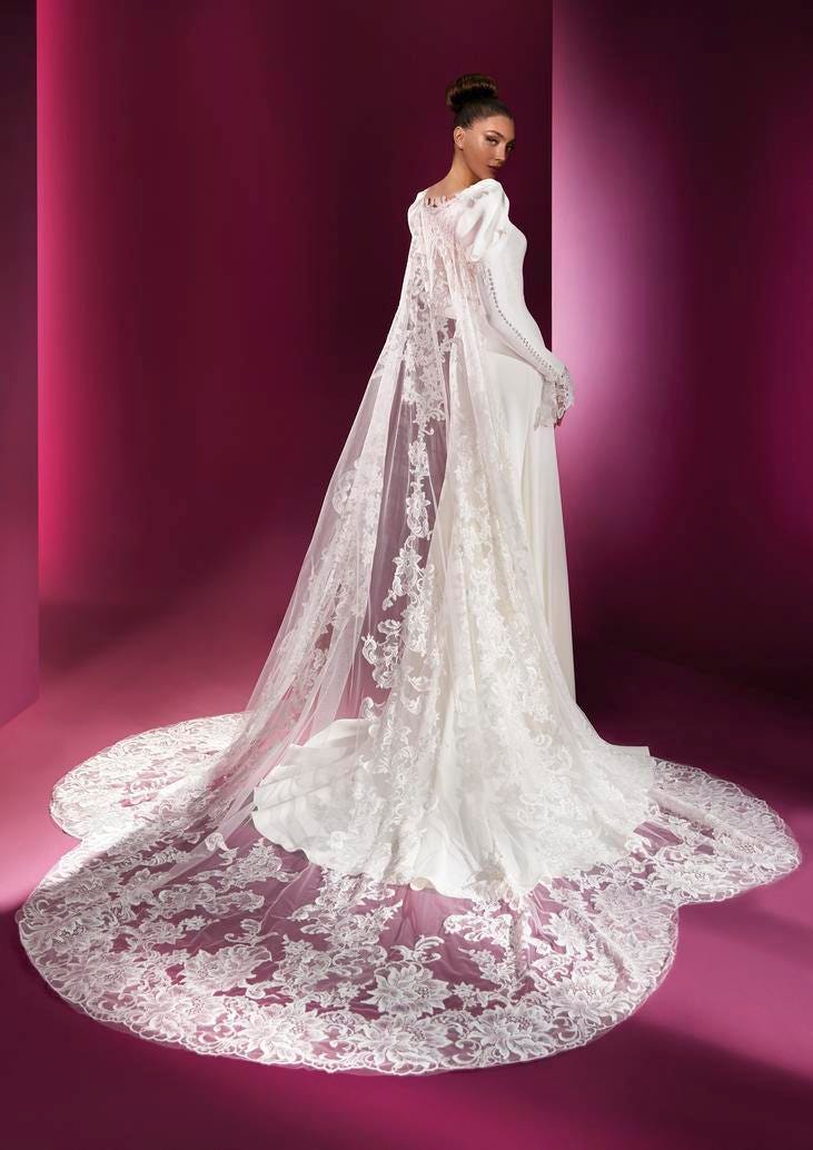 Elegante abito da sposa realizzato da Pronovias Atelier con maniche lunghe e strascico di pizzo
