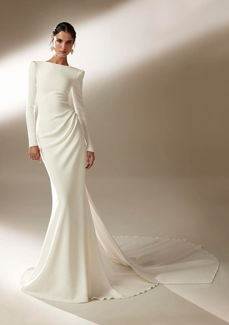 Mujer con vestido de novia minimalista con corte recto imperial, cuello barco y mangas largas