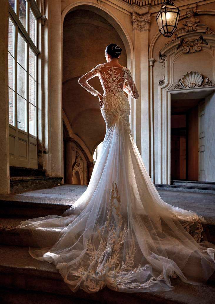 Une mariée arborant une robe de mariée sirène en dentelle à manches longues et dos transparent pour un look romantique