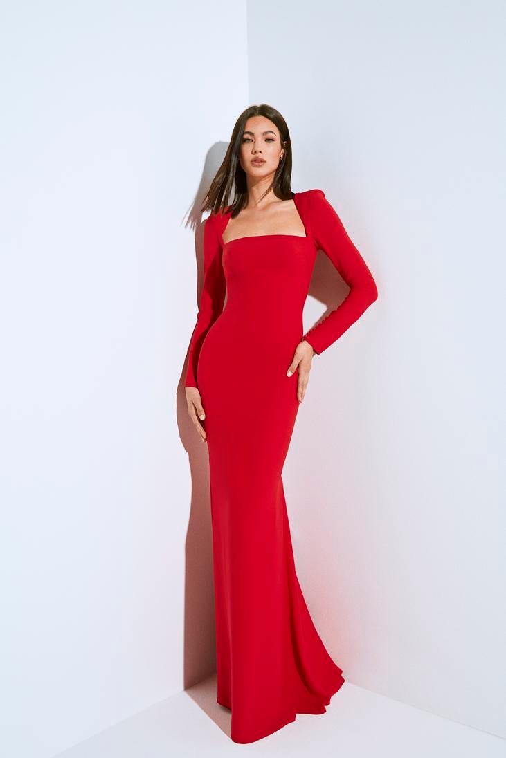 Brunette wearing a red high neck mermaid party dress in crepe, posing against a white background